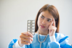 Woman pharmacist holding prescription medicine from doctor order
